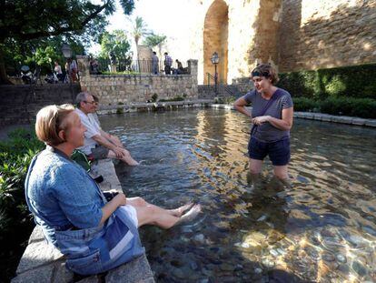 Unos turistas se refrescan en una de las fuentes de Córdoba.