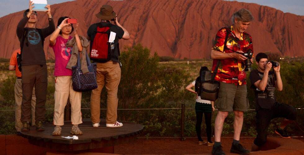 Turistas toma fotos del atardecer en el monolito de Uluru el 21 de abril de 2014.
