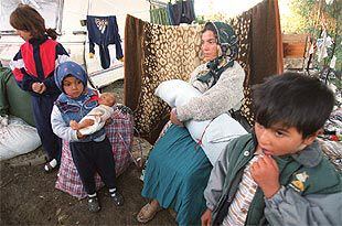 Una mujer, con su bebé en brazos y tres niños, poco antes de abandonar el poblado chabolista de El Salobral. ESCENA