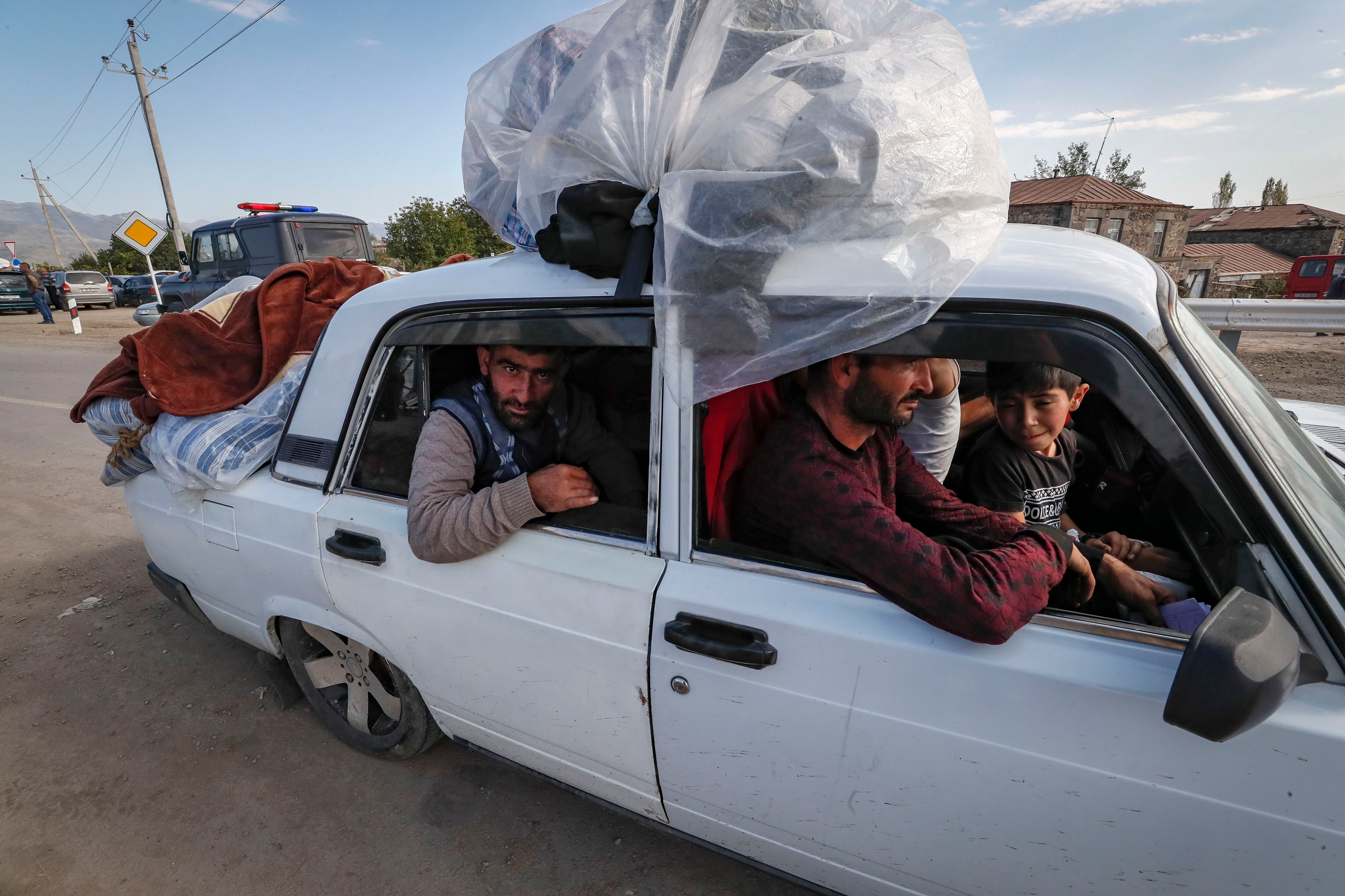 Varios civiles huyen en su coche de Nagorno Karabaj, este jueves en la localidad armenia de Kornizdor. 