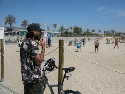 Un hombre fuma fuera de los límites de una playa sin tabaco, en Barcelona.