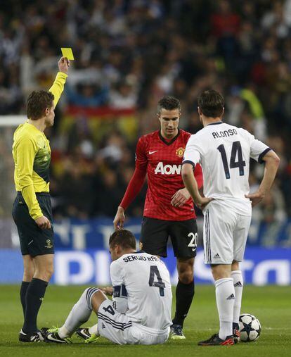 Robin van Persie ve la tarjeta amarilla por un manotazo a Sergio Ramos.