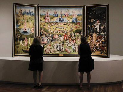 Dos visitantes observan El jard&iacute;n de las delicias, de El Bosco, expuesto en la actual muestra del Museo del Prado (Madrid).