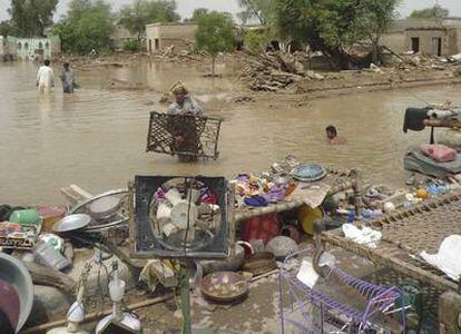 Pobladores paquistaníes tratan de rescatar lo poco que pueden salvar de sus viviendas destruidas por las inundaciones en el poblado de Dera Ismail Khan, en el noroeste del país