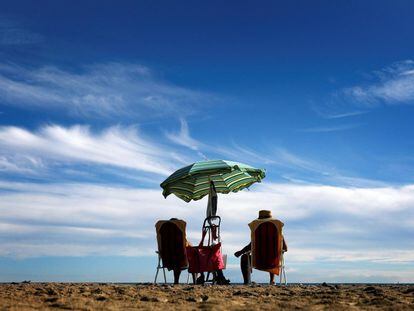Una pareja toma el sol en la playa de la Malvarrosa, en Valencia.