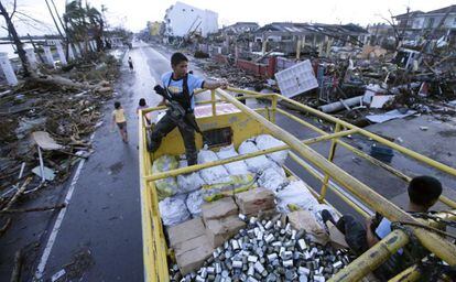 Policías vigilan un cargamento de comida para los damnificados en la ciudad de Tacloban, en la provincia de Leyte (Filipinas), 12 de noviembre de 2013, tras el paso del devastador tifón Haiyan.