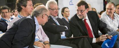Rajoy, se dirige al ministro de Hacienda, Crist&oacute;bal Montoro, en presencia del presidente del PP de Murcia, Ram&oacute;n Lu&iacute;s Valcarcel, y Carlos Floriano, en Murcia.