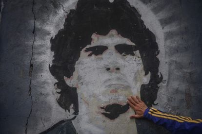 Un fan de Boca Juniors pone su mano en un mural de Diego Armando Maradona tras su muerte, el pasado miércoles.