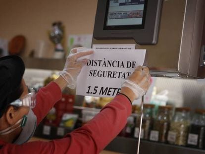 El encargado de un negocio de alimentación en Terrassa (Cataluña) coloca un cartel de advertencia en el mostrador el pasado lunes.