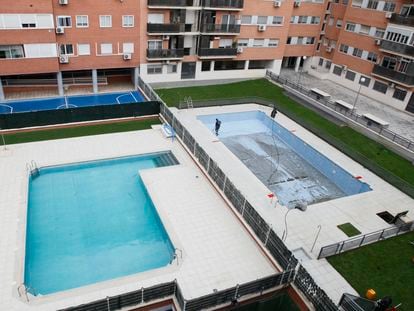 Trabajadores preparan la piscina de una comunidad de vecinos en una urbanización madrileña, en mayo.
