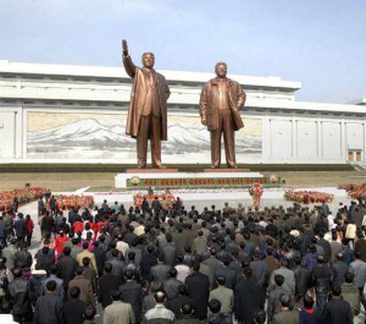 Decenas de norcoreanos participan en una ofrenda floral delante de las estatuas del fundador de Corea del Norte, Kim Il-sung, y de su hijo Kim Jong-il, en Piongyang.