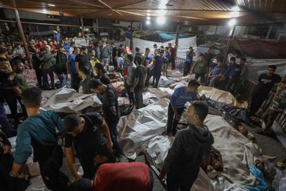 La gente se reúne alrededor de los cuerpos de palestinos muertos en el bombardeo al hospital árabe Al Ahli, en Gaza, este martes.
