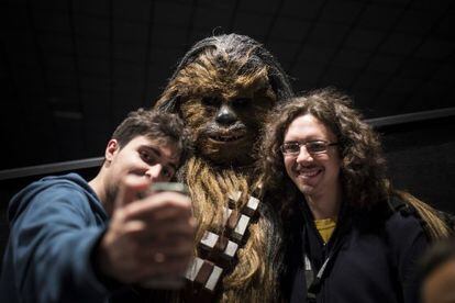 Dos participantes en el evento de Star Wars se fotografían con Chewbacca.