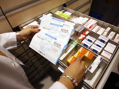 Una farmacéutica coteja recetas en papel en Boadilla.