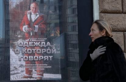 Una mujer pasa junto a una imagen del presidente ruso, Vladímir Putin, este lunes en Moscú, Rusia.