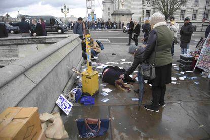 Una mujer herida yace en el suelo frente al Parlamento.