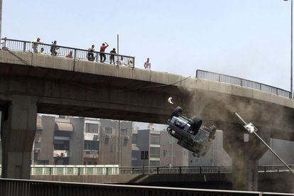 Manifestantes tiran un coche la policía por el puente 6 de Octubre de El Cairo.