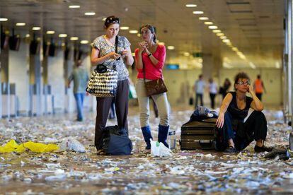 Tres pasajeras ayer en el Aeropuerto de El Prat con el suelo lleno de basura