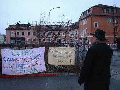 Un hombre ante carteles de protesta contra el incendio de un hotel, este lunes en Bautzen (Alemania).