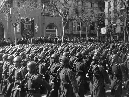 Tropas españolas, ataviadas con cascos italianos, desfilan por las calles de Barcelona el 27 de enero de 1942 durante la parada militar organizada con motivo del III aniversario de la conquista de la ciudad.