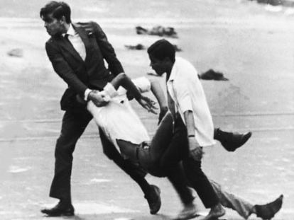 Dos hombres con uno de los estudiantes muertos cerca de la embajada de EE UU, en Rio de Janeiro, en 1968. 