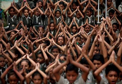 Estudiantes de un colegio rezan durante en un temo de Ahmedabad (India).