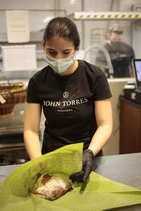 Desde la tienda de John Torres se ve trabajar al cocinero Adrián Collantes en el obrador.