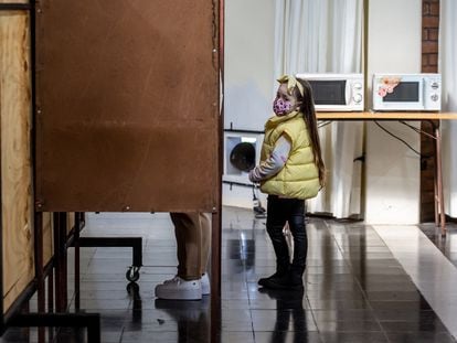 Una niña espera junto a una casilla mientras su madre vota, en la ciudad de Osorno, durante el plebiscito constitucional de septiembre de 2022.