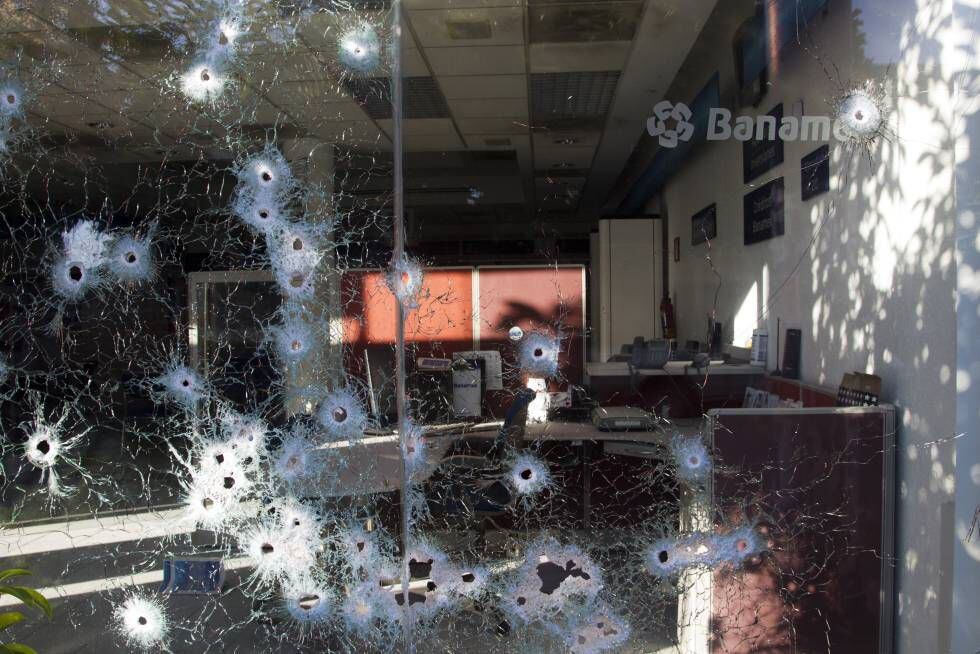 Impactos de armas de alto calibre en una sucursal bancaria que habría quedado atrapada en un tiroteo.