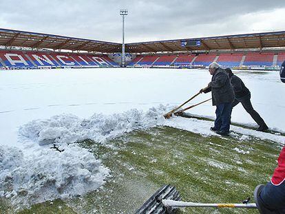 Operarios retiran la nieve en el estadio de Los Pajaritos de Soria, donde jugará el Madrid el domingo.