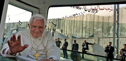 Benedicto XVI pasa junto al muro que separa Israel y Cisjordania, en su visita al campo de refugiados de Aida, cerca de Belén, el 13 de mayo de 2009. El Papa condenó la política de Israel contra los palestinos. "En un mundo donde cada vez más fronteras se abren al comercio, los viajes, los movimientos de personas y el intercambio cultural, es trágico ver como se alzan todavía muros", dijo. El Pontífice reivindicó para el pueblo palestino el derecho "a una patria soberana en la tierra de sus antepasados, segura, en paz con sus vecinos y con fronteras reconocidas internacionalmente".