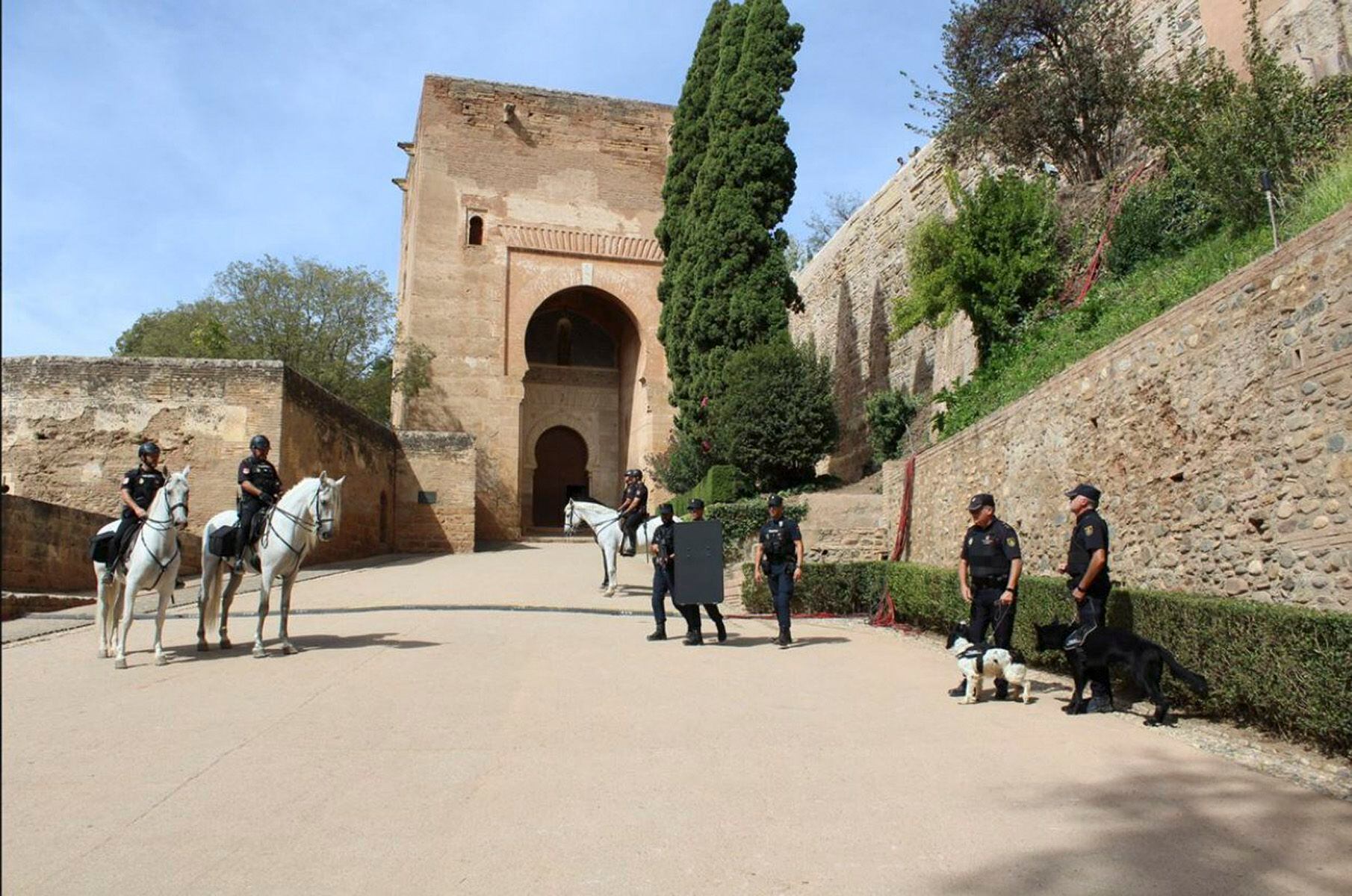 Policías a caballo y con unidades caninas frente a la puerta de la Justicia de la Alhambra, el jueves.