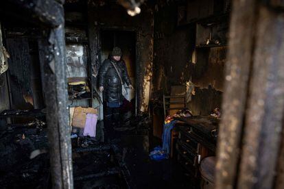 A woman observes this Tuesday what remains of her house practically reduced to ashes by the fire caused by a bombing in kyiv. 