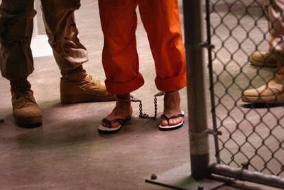 Un detenido con grilletes es conducido por dos militares en Guantánamo en 2009.