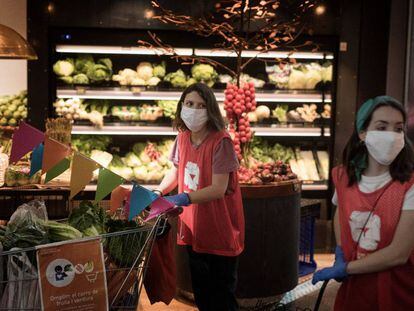 Dues voluntàries de l'ONG De Veí a veí recollint aliments al mercat de Sant Antoni.