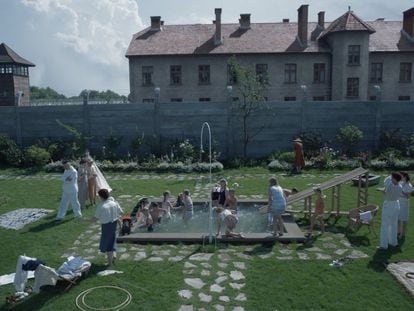 Una imagen de 'La zona de interés', con el jardín de la casa del comandante de Auschwitz y, al fondo, el muro del campo de exterminio.