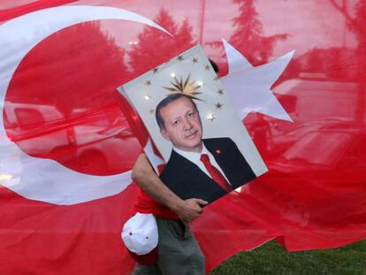 Un seguidor de Tayyip Erdogan, presidente turco, transporta una foto suya, ante la sede del partido AKP, en Estambul.