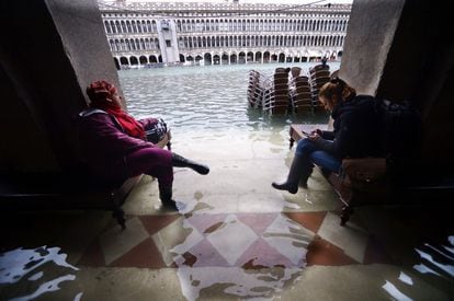 Dos personas contemplan la inundada plaza de San Marcos en Venecia, este viernes.