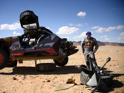 Stéphane Peterhansel contempla la rueda de su Audi después de un accidente en la primera etapa del Dakar, en Hail.