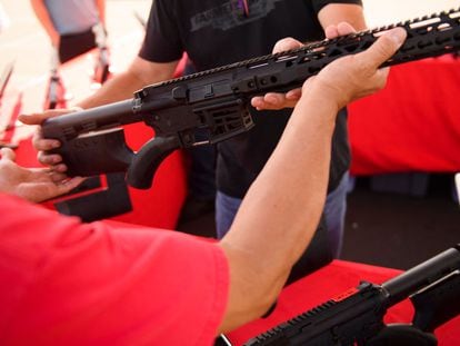 Una persona observa un rifle AR-15 en un mercado de armas en Costa Mesa, California.