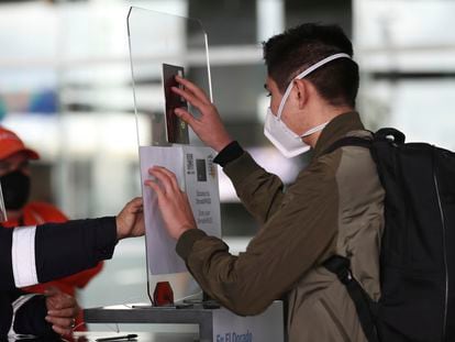 Un pasajero escanea su pasaporte antes de abordar un avión en El Dorado, Bogotá (Colombia).