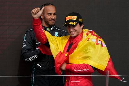 El piloto español de Ferrari, Carlos Sainz, celebra su victoria en el Gran Premio de Gran Bretaña de Fórmula Uno mientras el piloto británico de Mercedes, Lewis Hamilton, mira hacia atrás, en el circuito de Silverstone