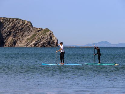 Aketza Sánchez e Idoia Fuertes recorren en pádel-surf las playas de Gorliz (Bizkaia) en busca de microplásticos.