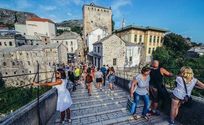 Visitantes sobre el puente de la ciudad vieja de Mostar.