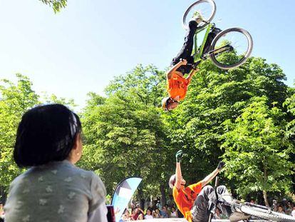 Jóvenes ciclistas hacen acrobacias en el Retiro durante la celebración del Día del Deporte.