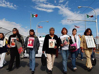 Familiares y amigos de las mujeres asesinadas en Ciudad Juárez llevan sus fotos en una manifestación.