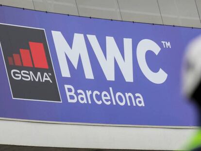 Un operario con mascarilla junto al logo del MWC de Barcelona, cancelado este año por el coronavirus.