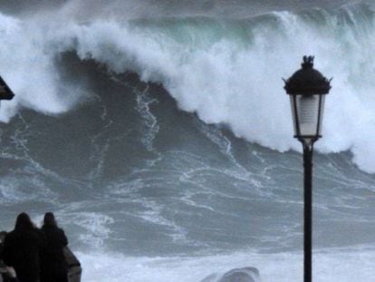 Varios turistas graban las olas este jueves en la costa de Muxía (A Coruña).