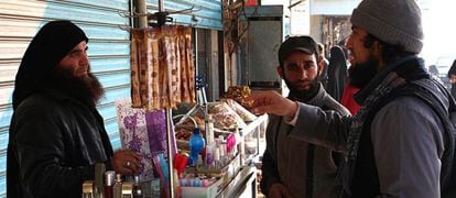 Un miliciano del EI habla con un vendedor de perfume en Raqqa.