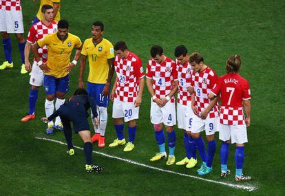 El &aacute;rbitro Nishimura vierte el aerosol ante los jugadores croatas.